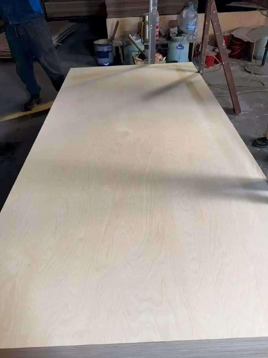 Full birch plywood sheet being inspected on a production table